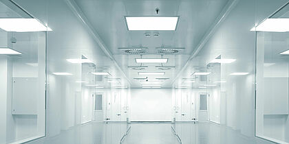 Inside a cleanroom facility. Windows on either side looking down a hallway